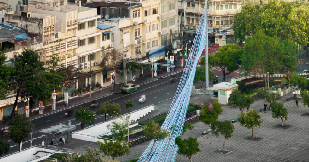 fabric ribbons form urban canopy over bangkok’s streetlights
